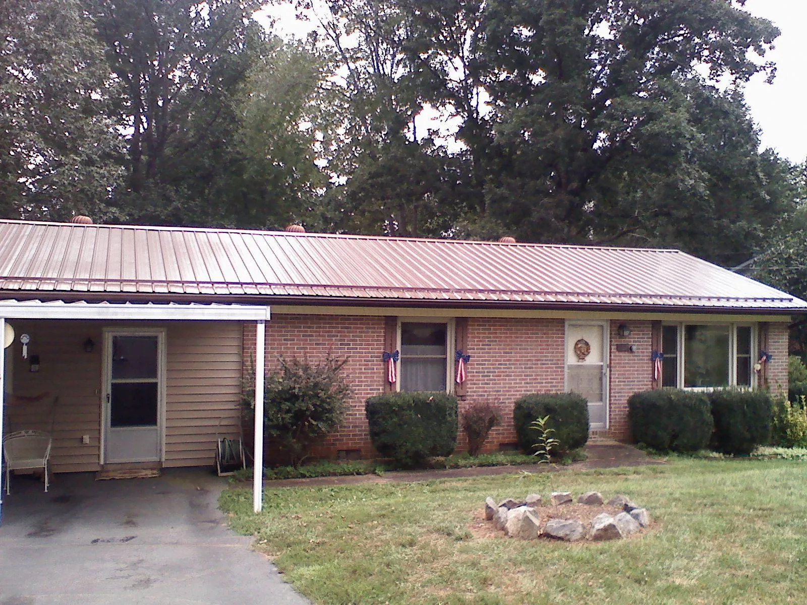 Bronze metal roof and carport on a brick ranch home — Roof Repair work by our crew in Norris
