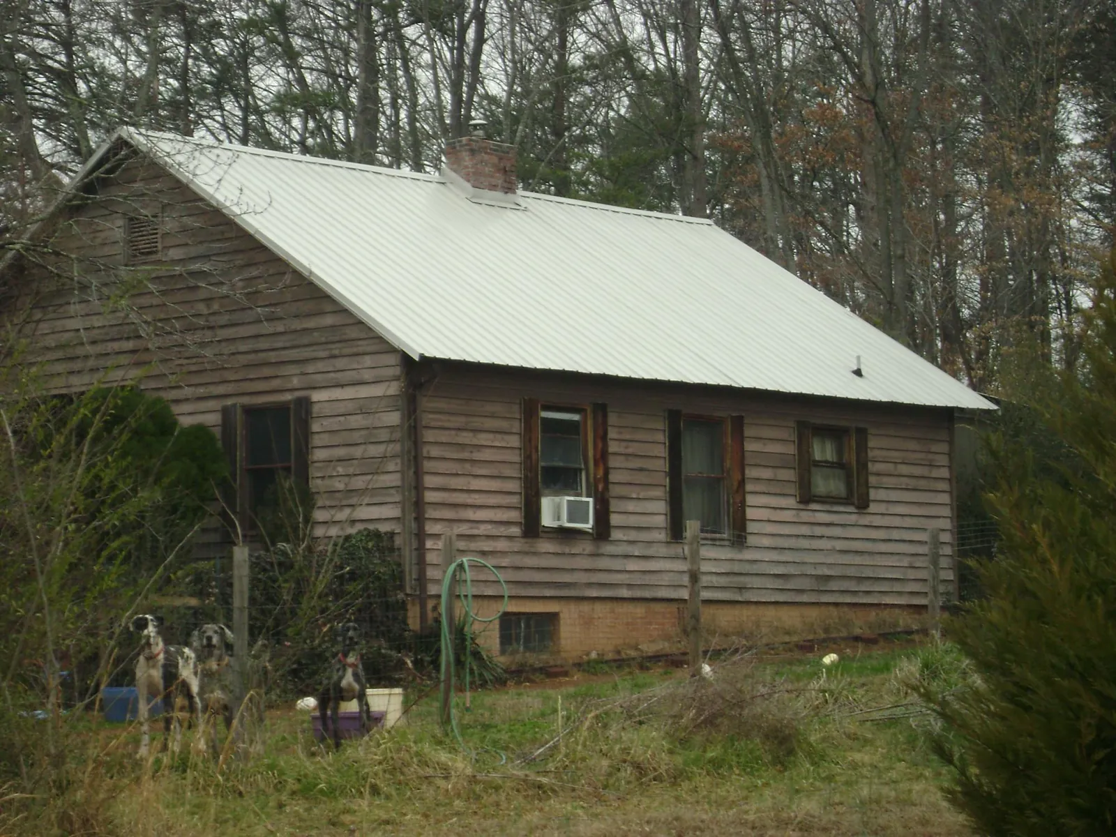 White metal roof on an old wood sided farmhouse, from a Metal Roof Installation job in Norris